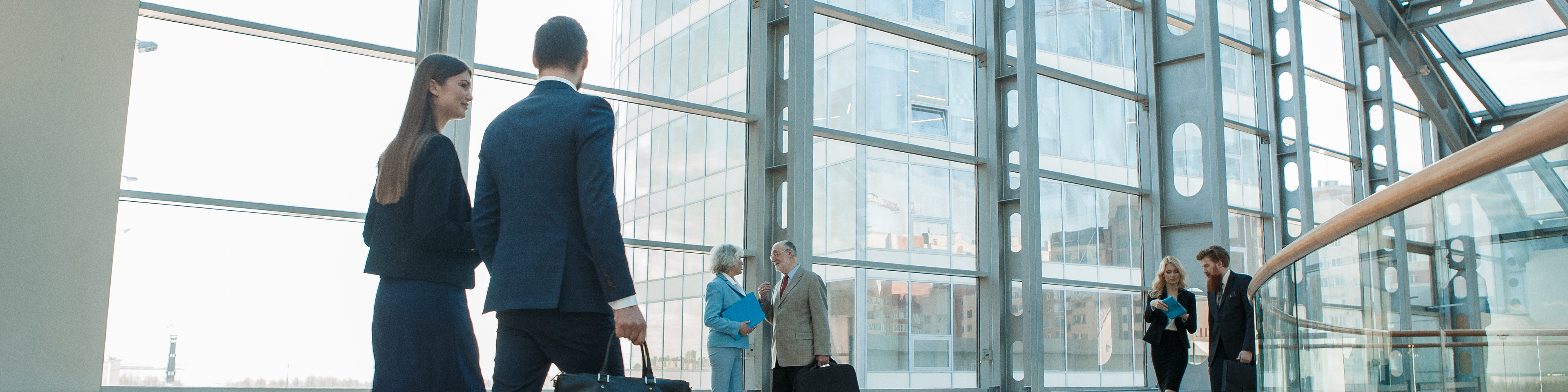 business people walking in glass building