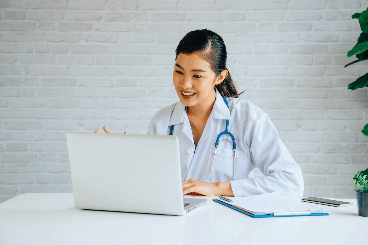 Asian female doctor working on a laptop