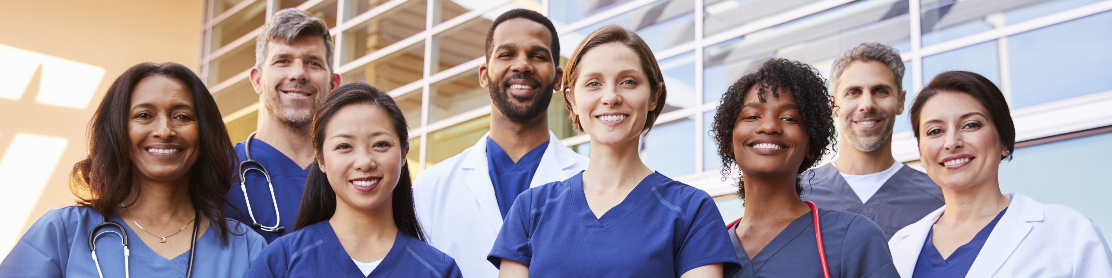 Smiling medical team standing together outside a hospital