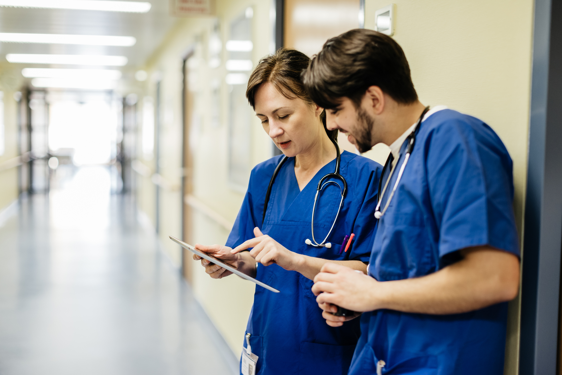 Doctors Discussing Data On Digital Tablet