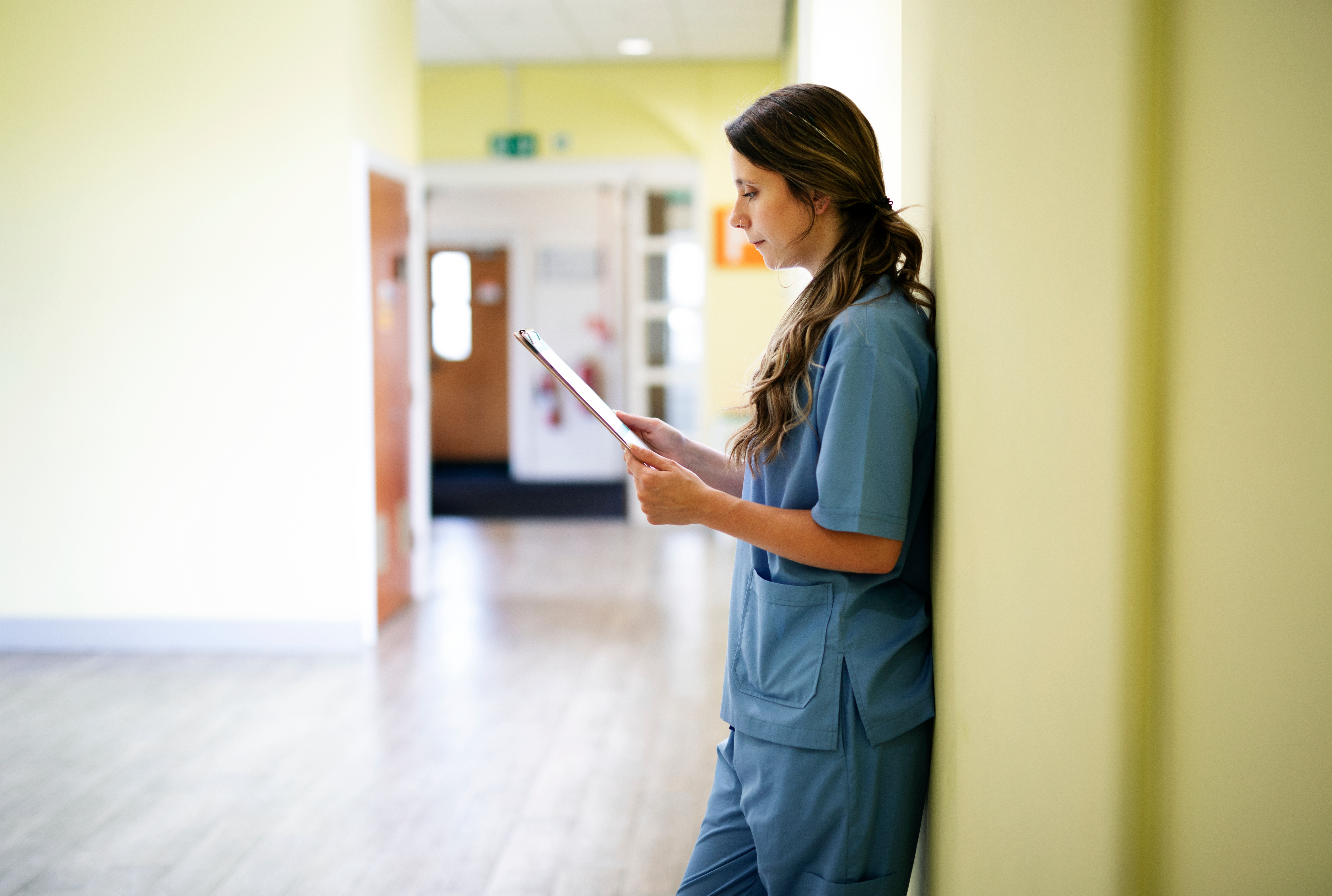 Nurse reading through medical records in the hallway