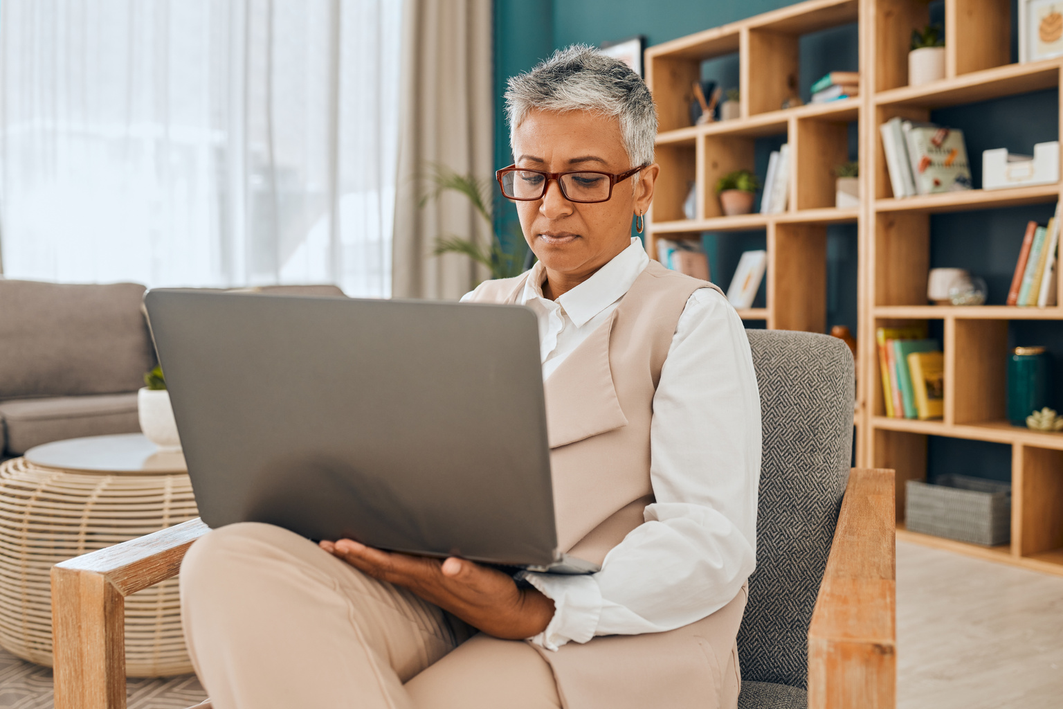 Mental health professional sitting in office chair working on laptop