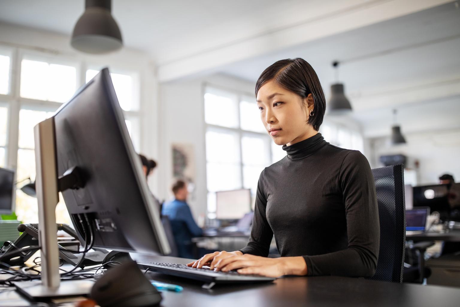 Woman busy working at her desk in open plan office