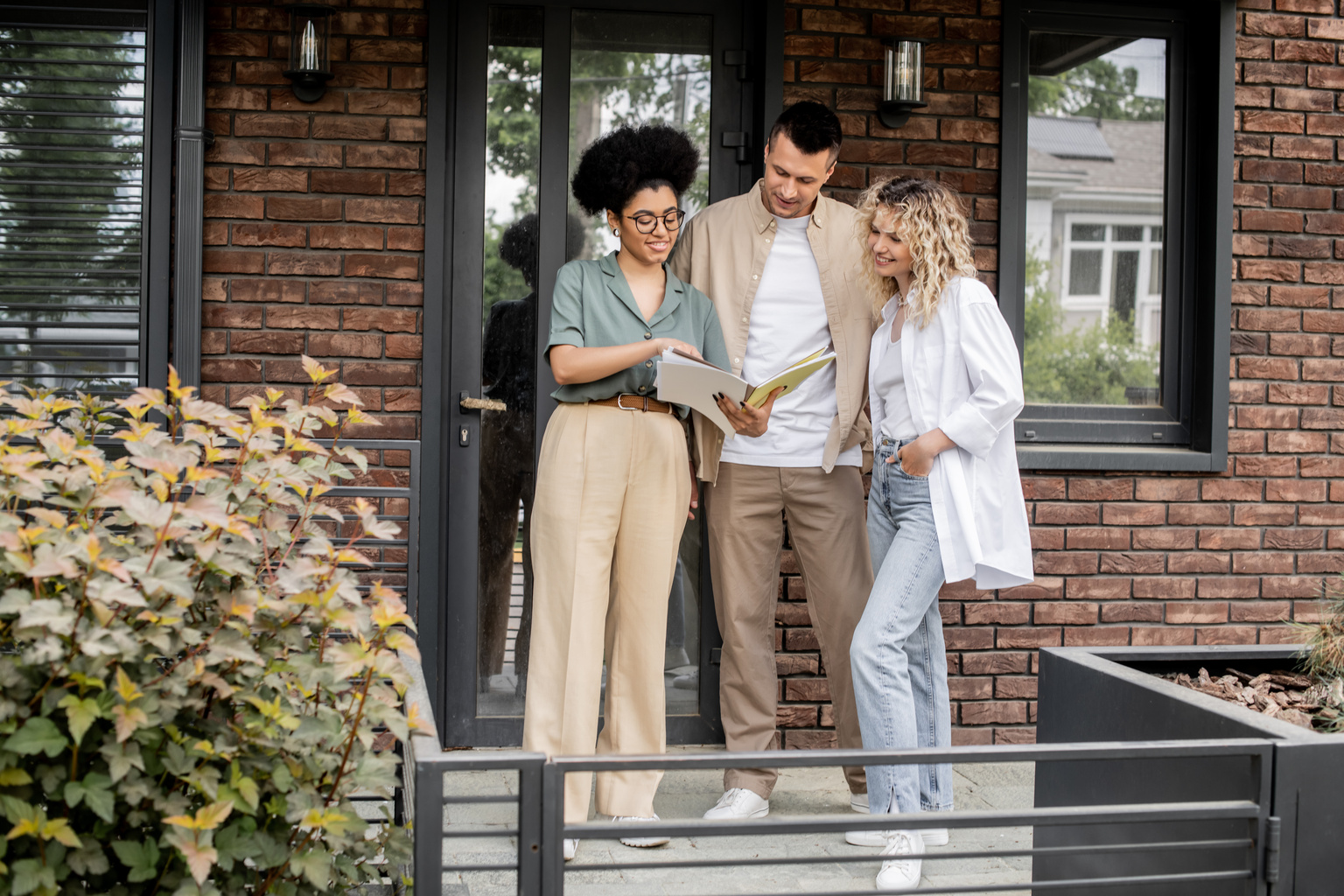 Real estate agent showing documents to smiling owners of new house