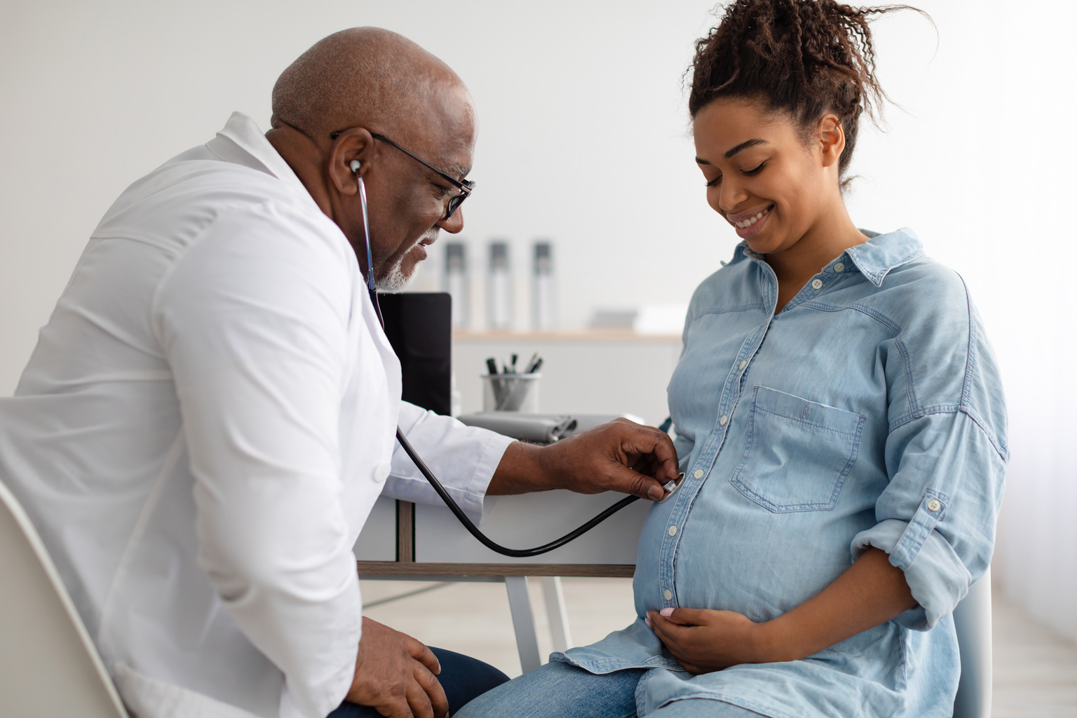 Male experienced doctor examining young pregnant woman