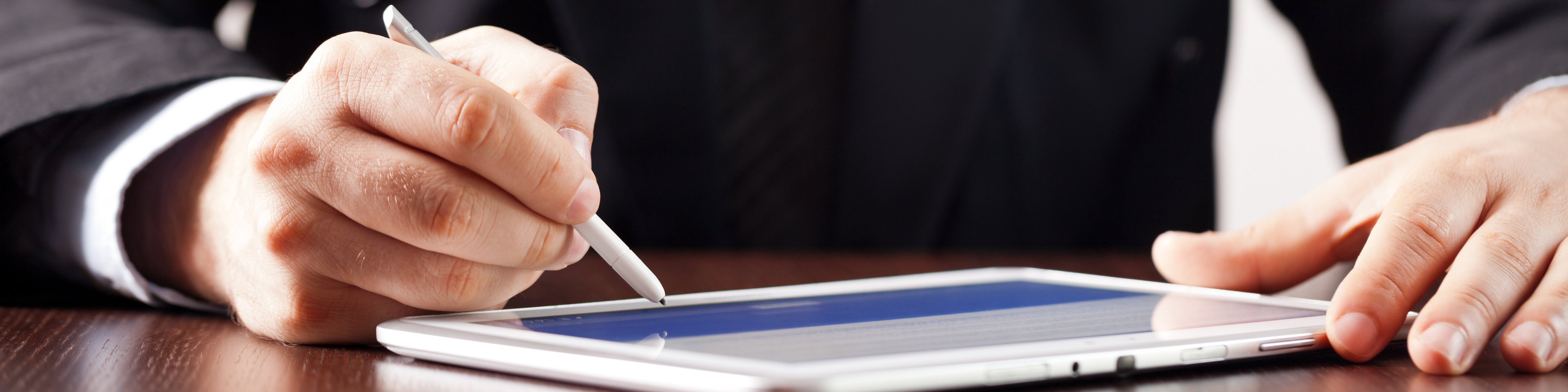 Man signing tablet with stylus