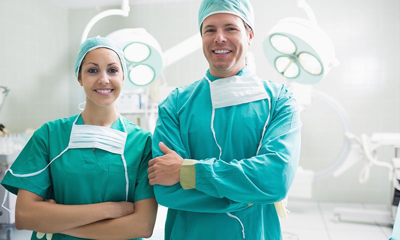 Two surgeons standing side-by-side in an OR