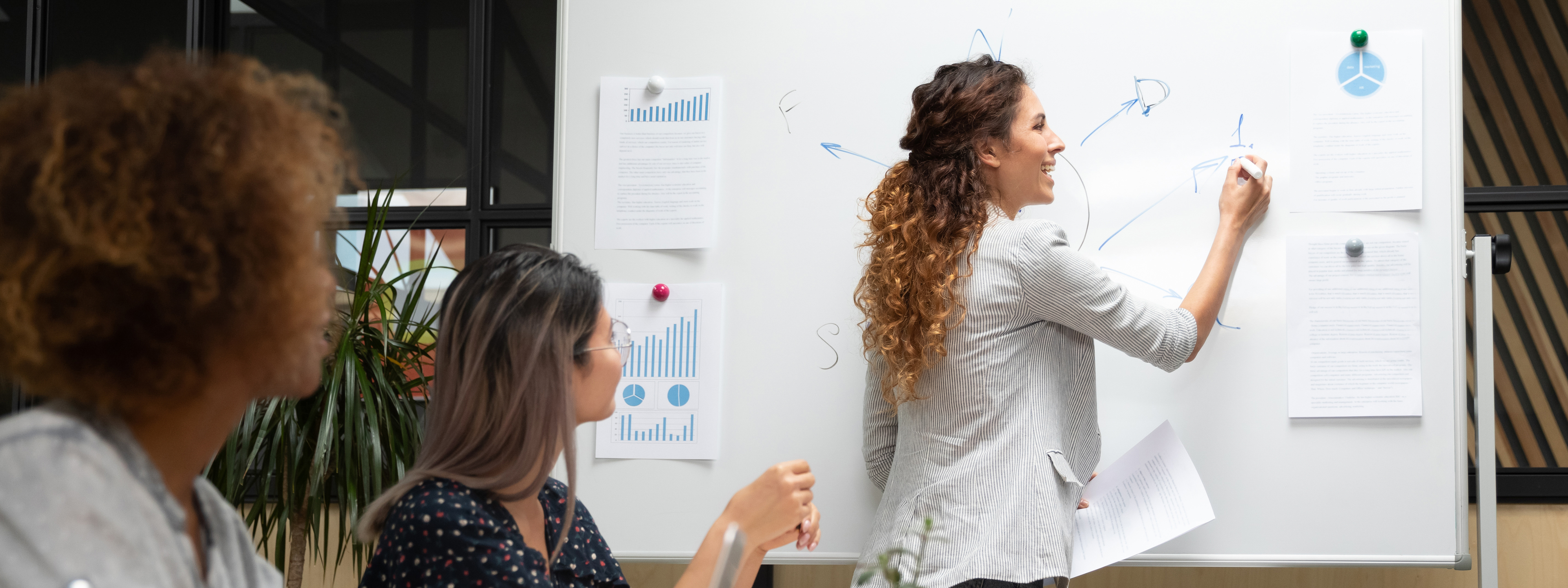 Business woman writing on a whiteboard during her presentation