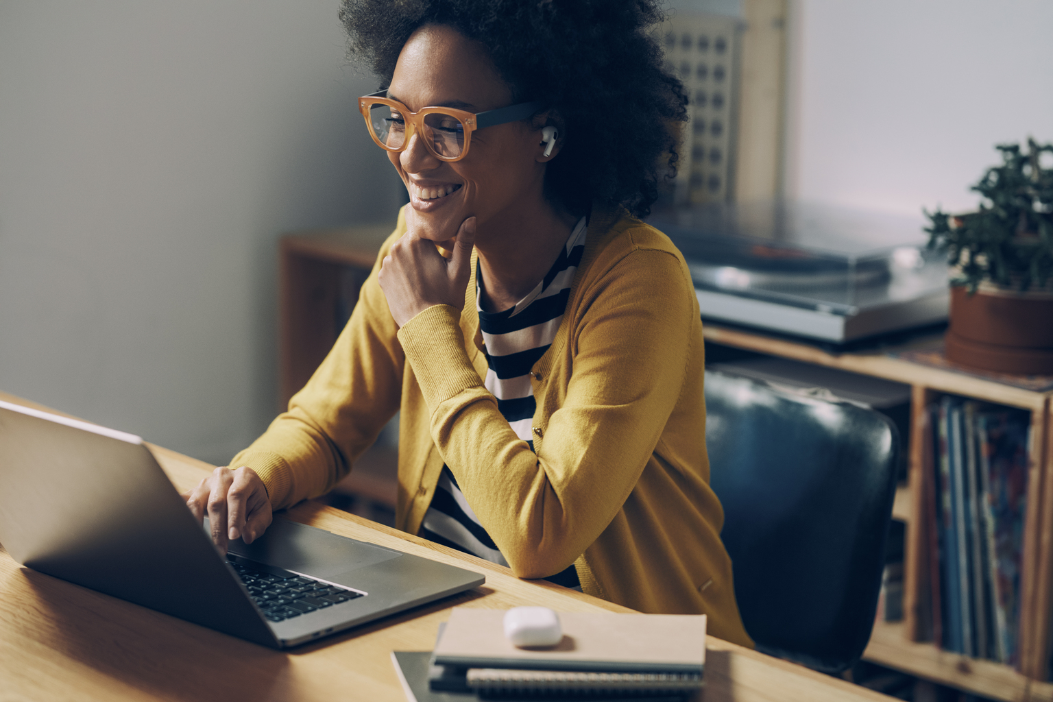 Working from home in the era of the new normal: a happy mixed race woman attending an online meeting.