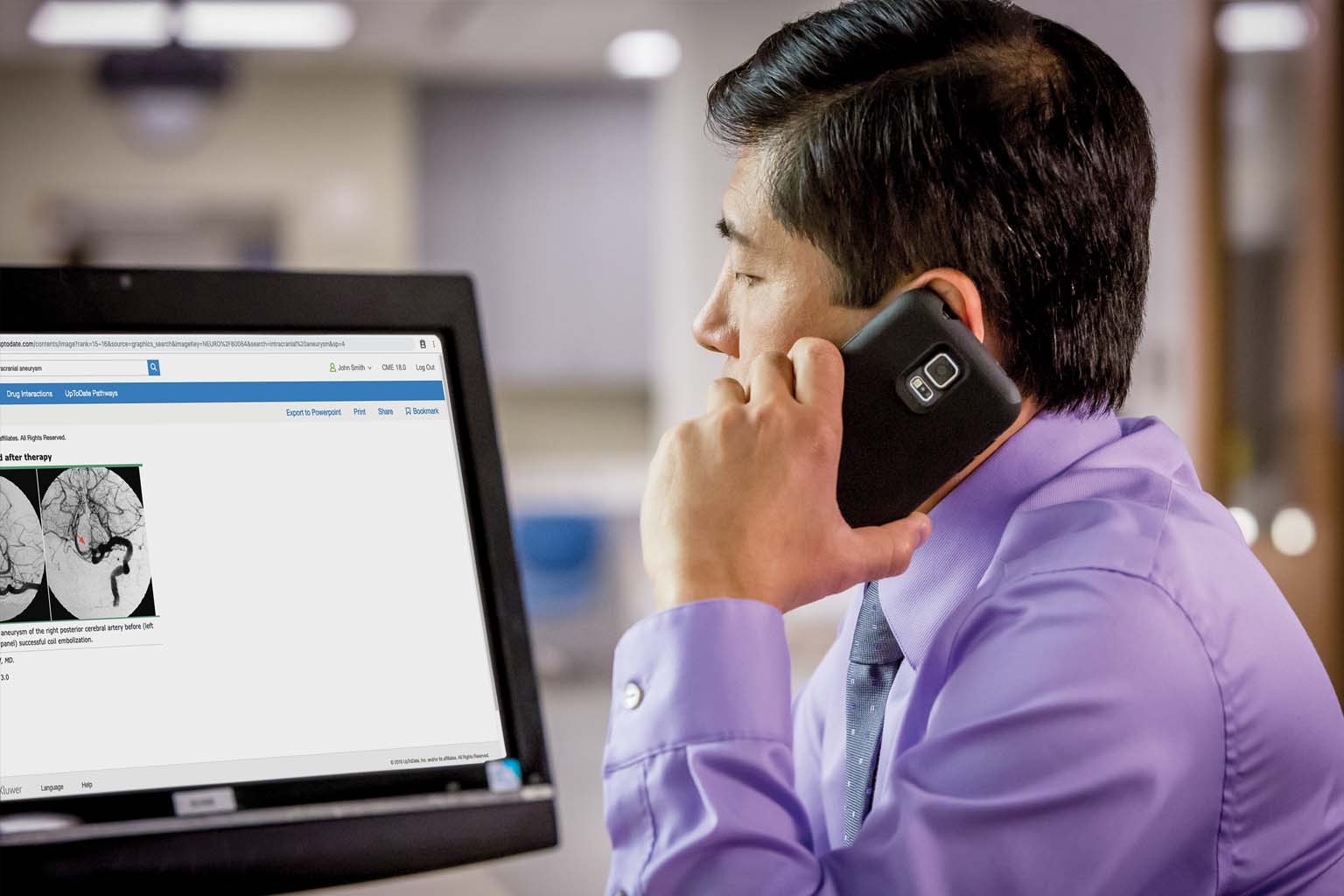 doctor at computer talking on phone