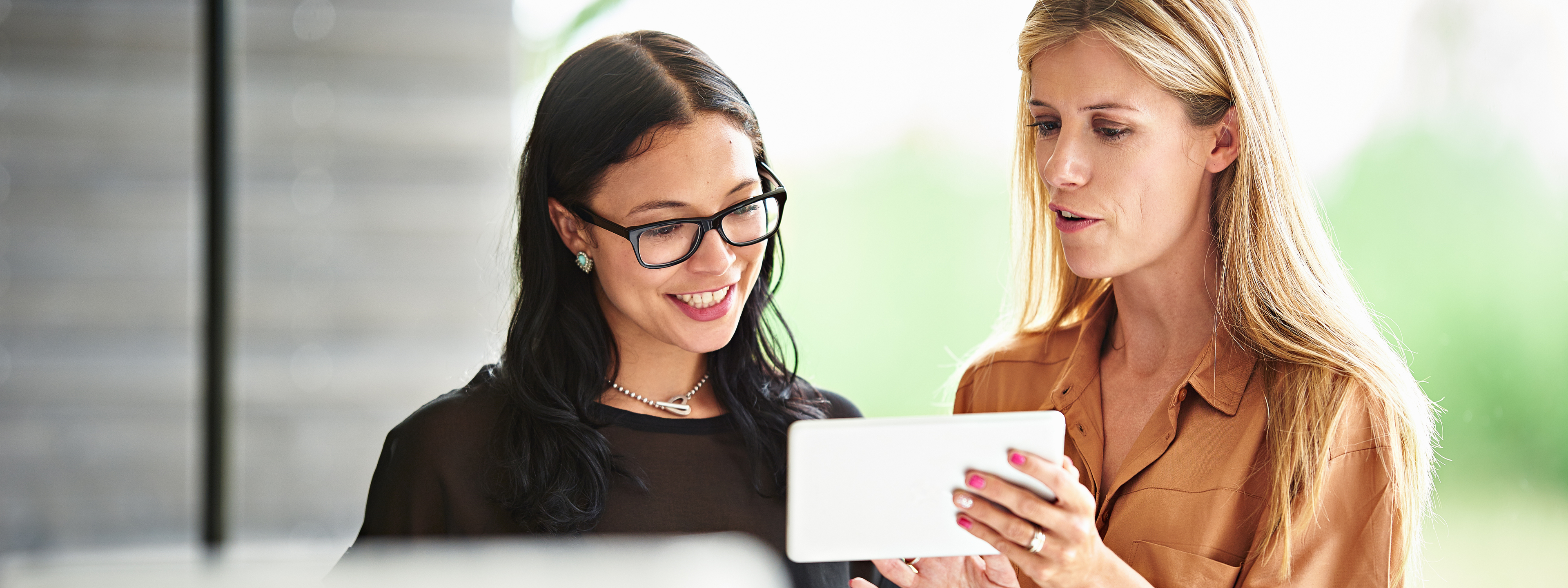 Two Business woman discussing over a device