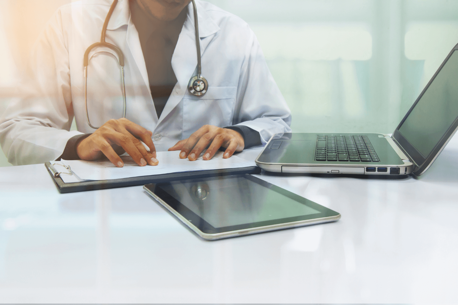 medicine-doctor-working-with-computer-notebook-and-digital-tablet-at-desk-in-the-hospitaljpg