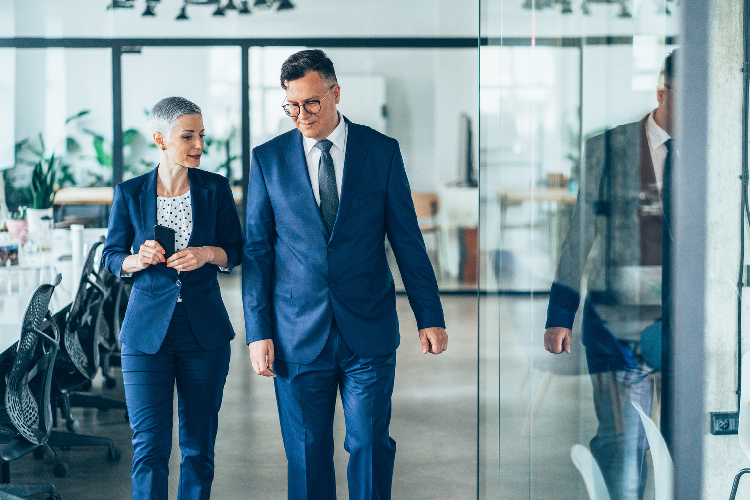 Business people walking and talking discussing ideas in the office