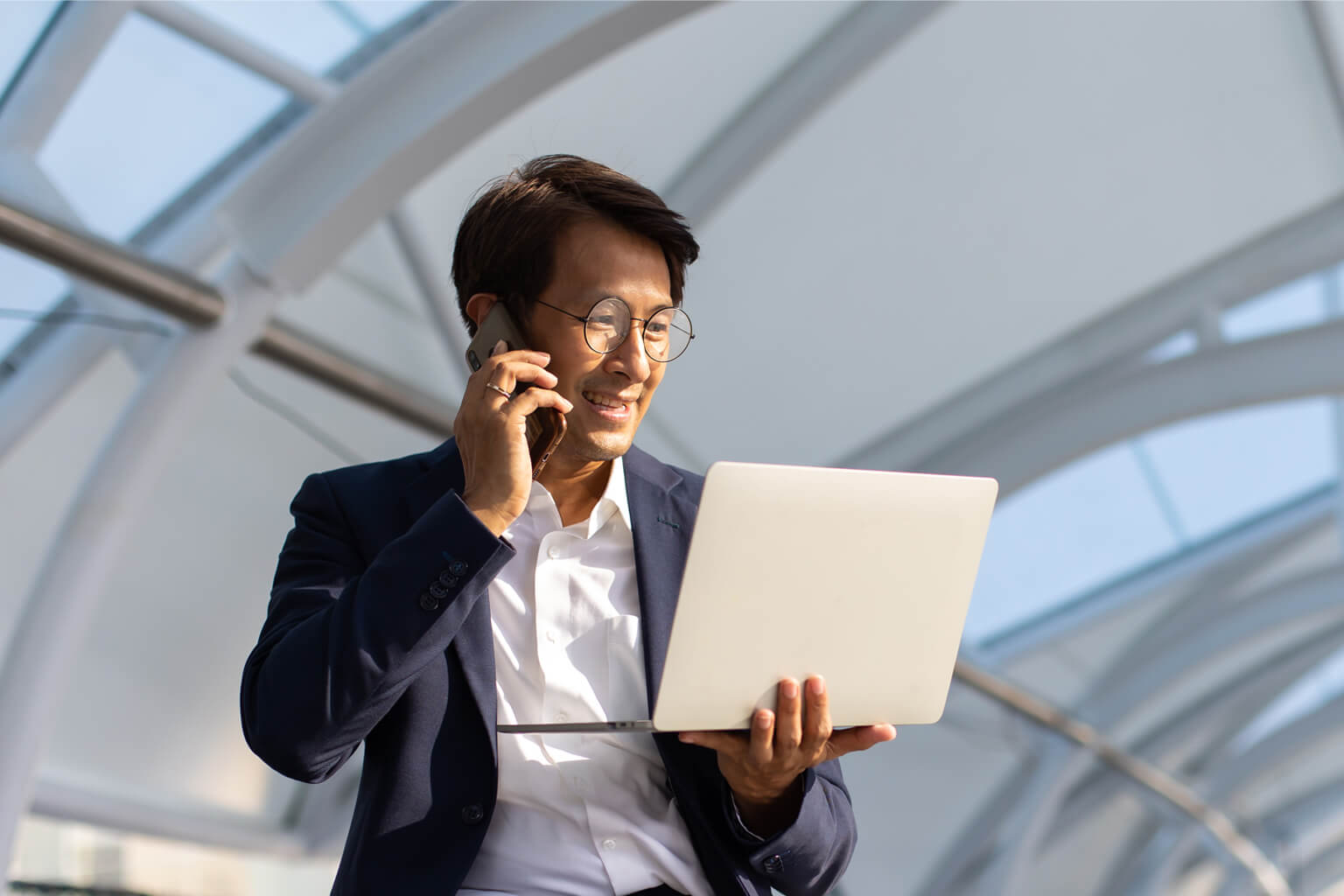 Accountant talking on the phone while holding a laptop