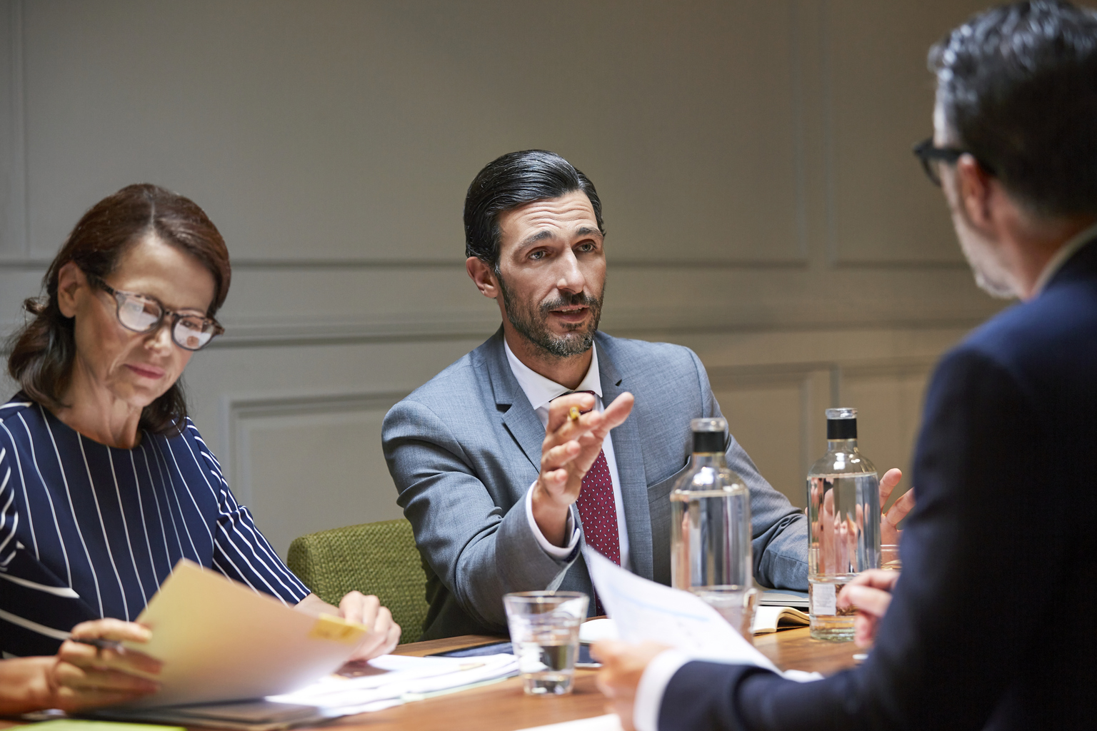 Mature businessman discussing with male colleague in meeting