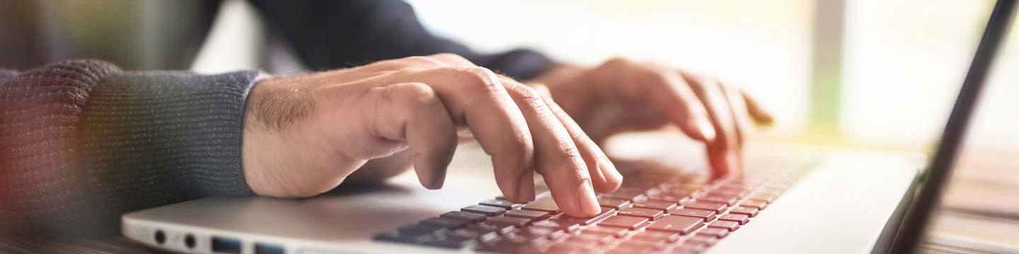 hands typing on a computer