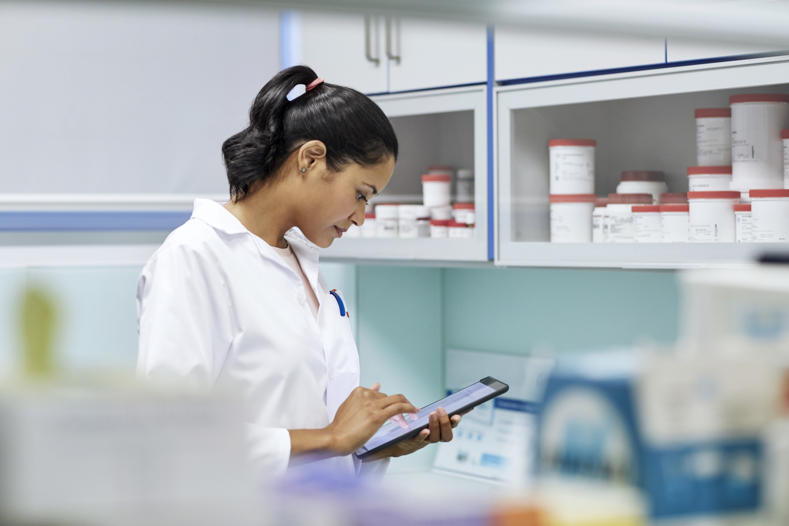 Young female scientist using tablet computer in hospital.