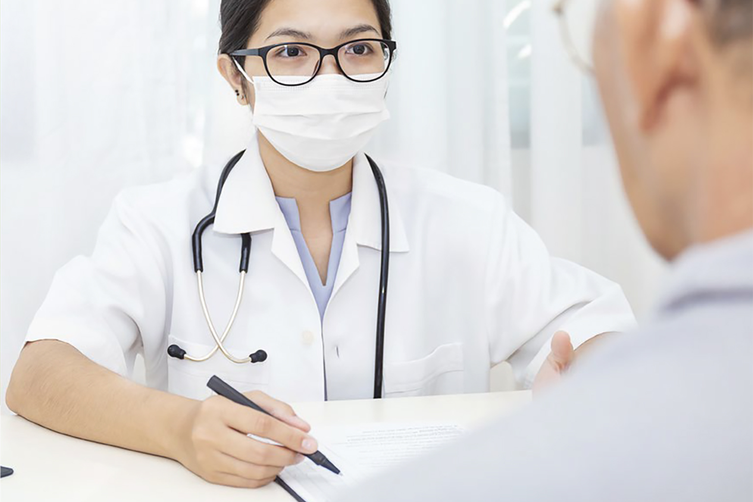 Doctor wearing face mask, meeting with patient