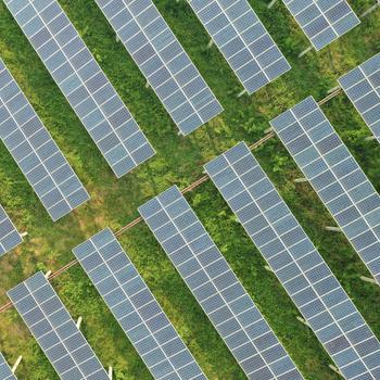 Solar panels stationary rows, solar power stations in high angle view isolated over green grass fields background / Solar panels stationary rows isolated over green grass fields background