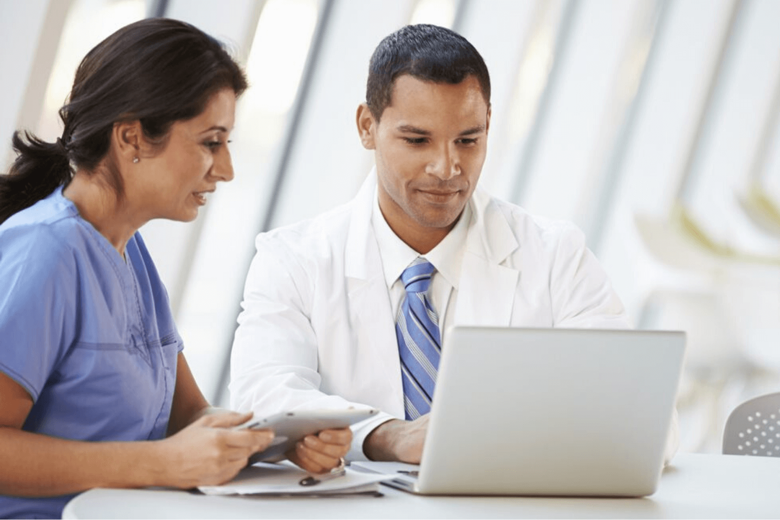 Two medical professionals looking at a laptop