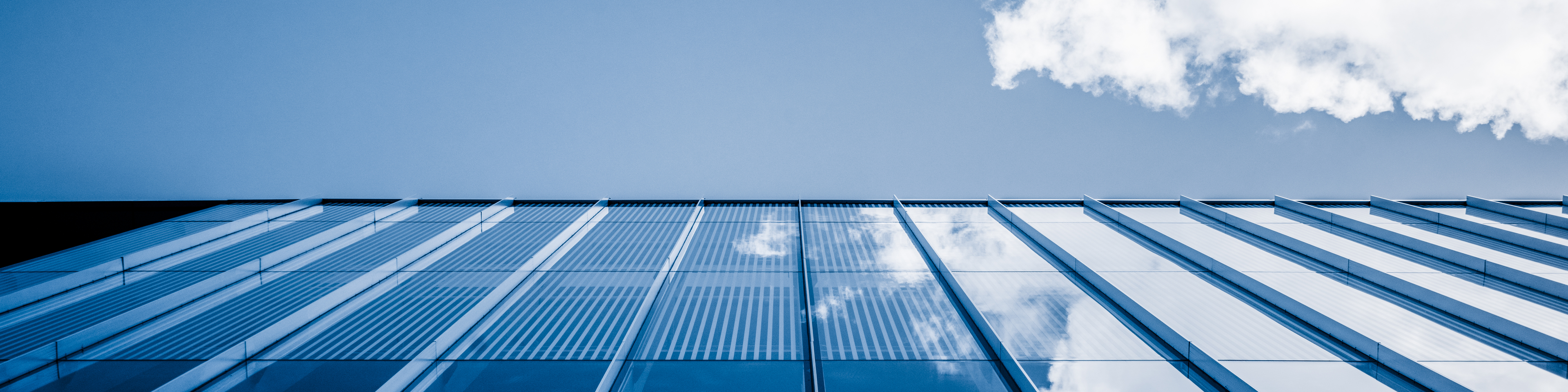 Clouds reflected in windows of modern office building,