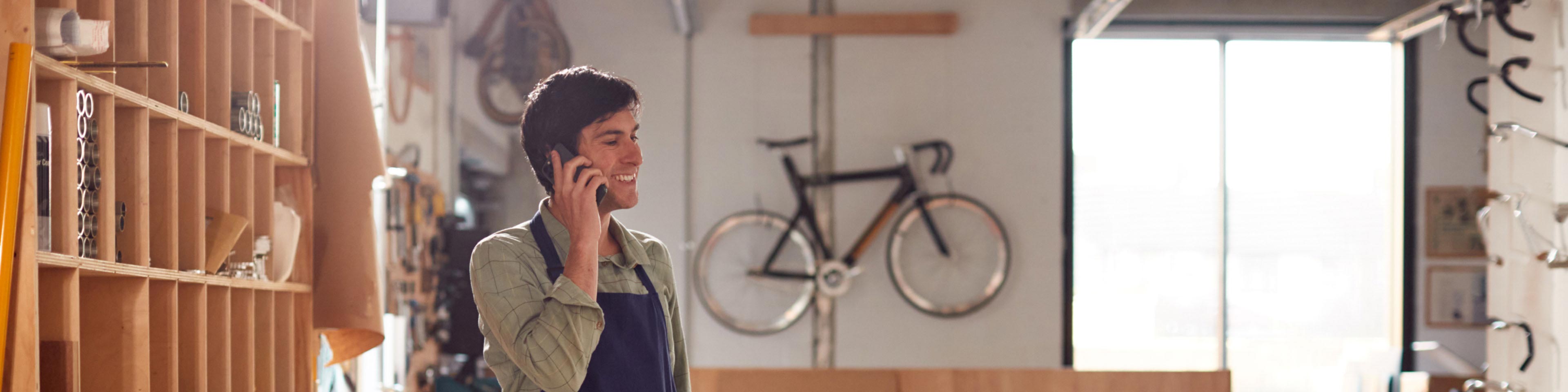 man in a bikeshop making a phone call about accounting for cash transactions