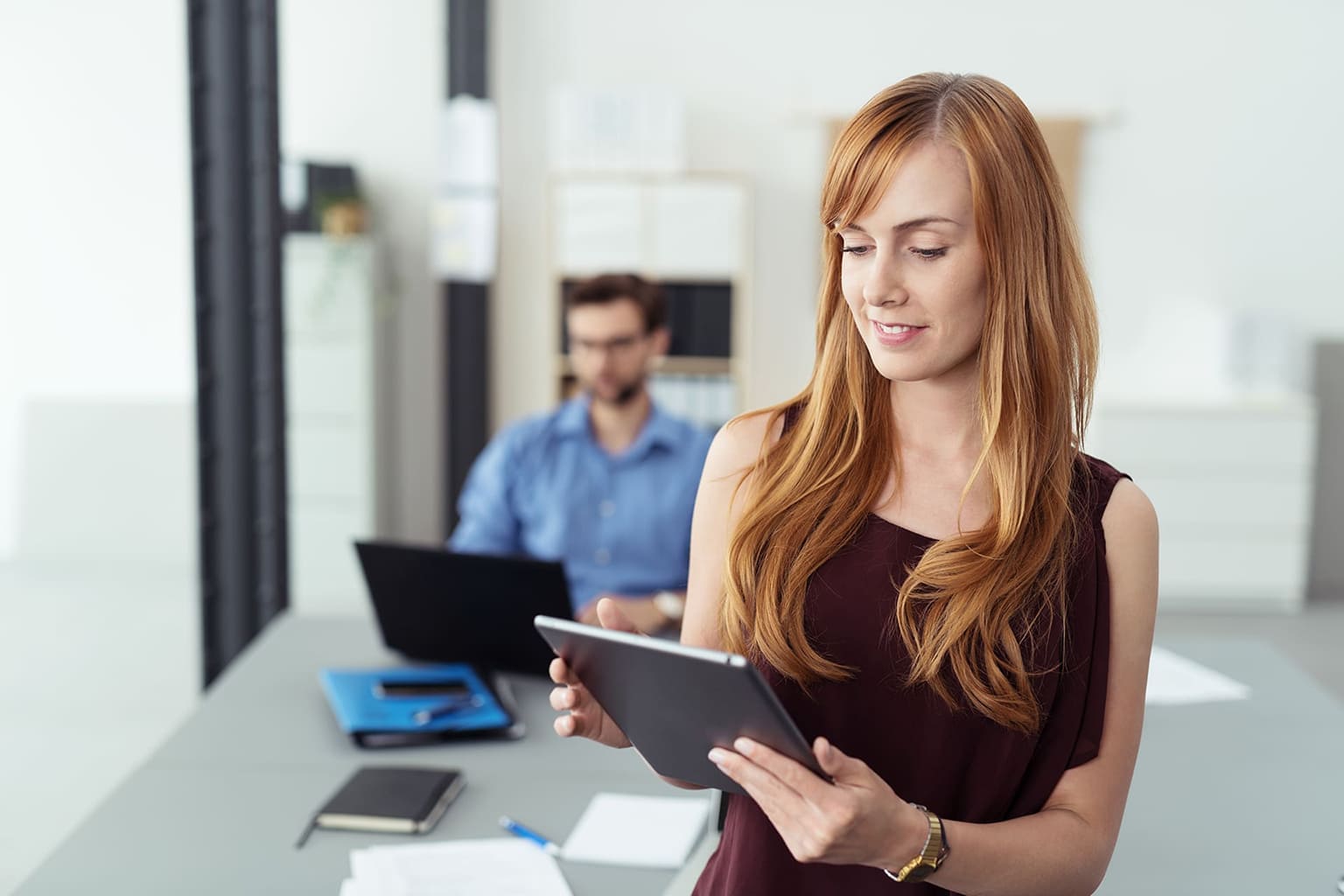 Vrouw en man op kantoor kijkend naar laptop