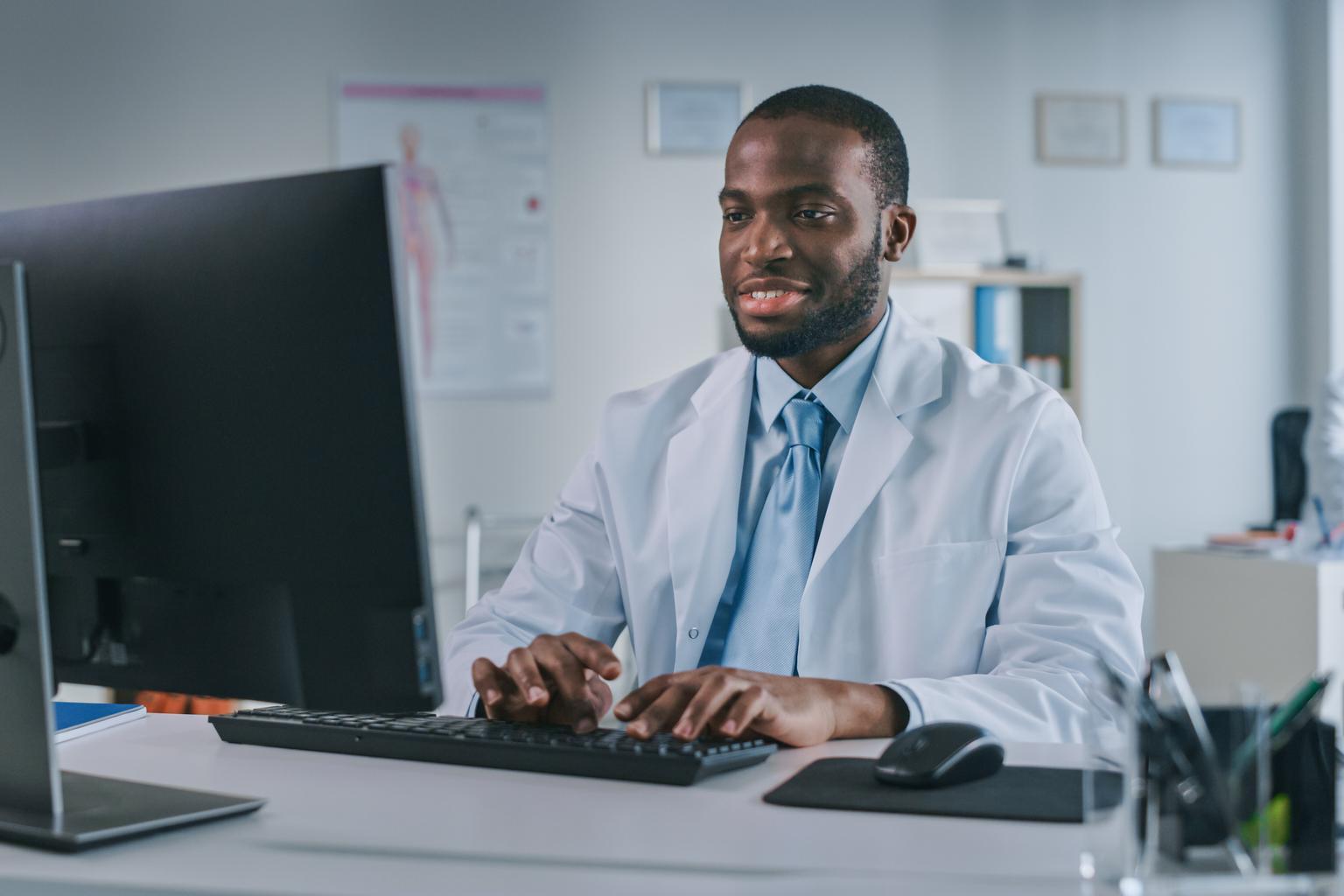 Black doctor sitting at a computer