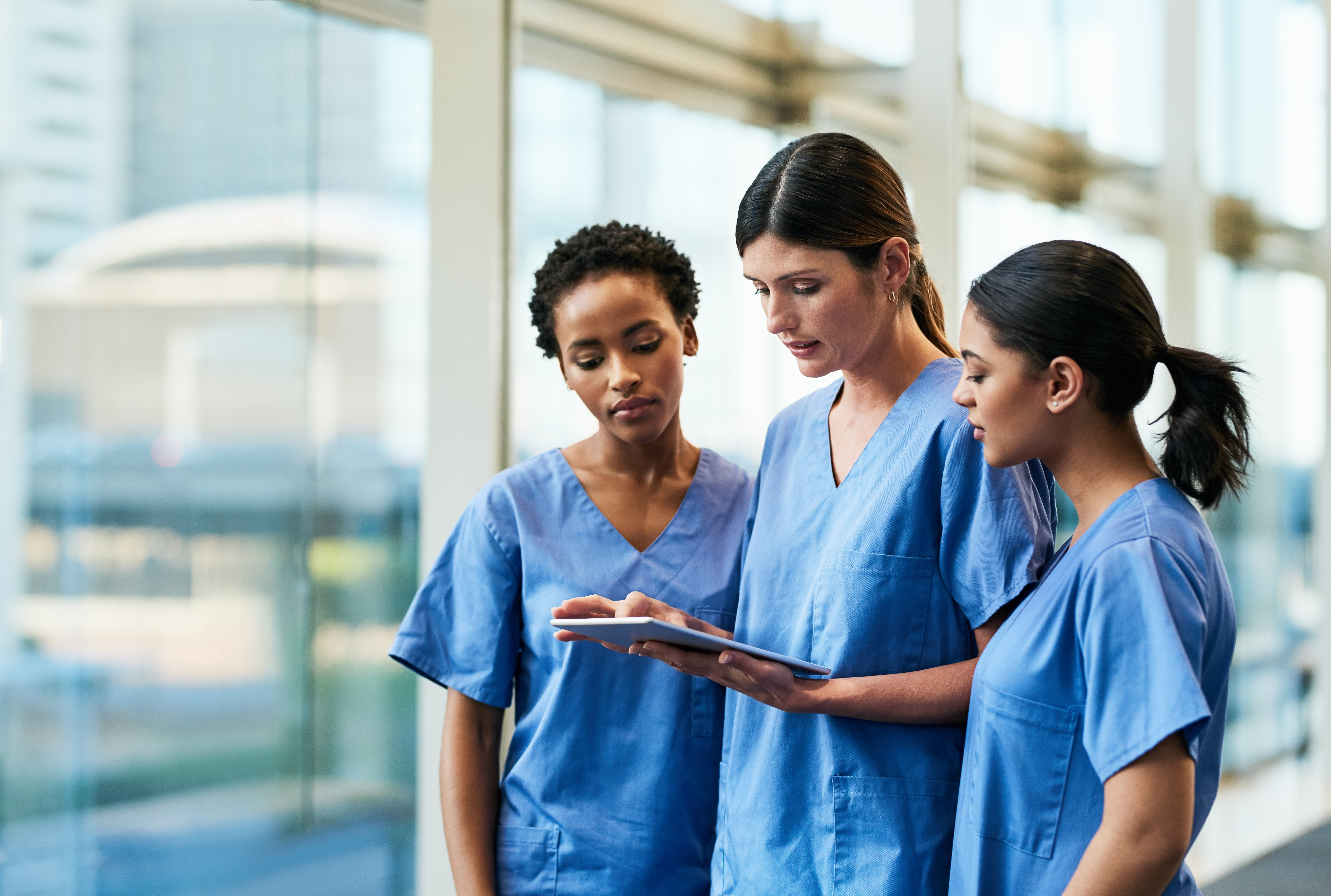 Group of nurses reviewing material on a tablet