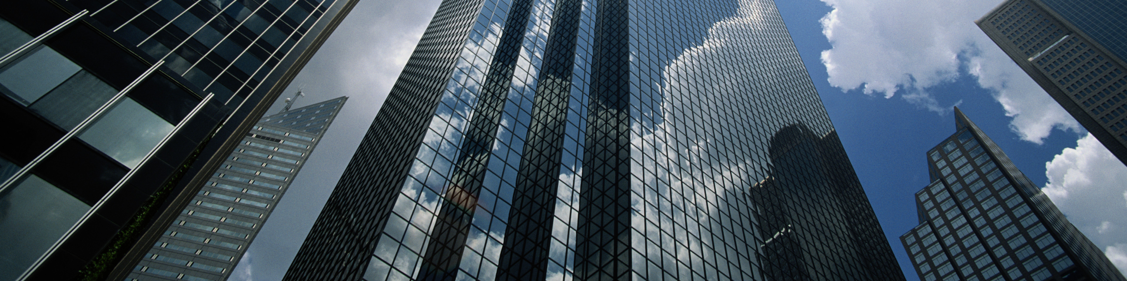 Office buildings reflecting clouds, low angle view