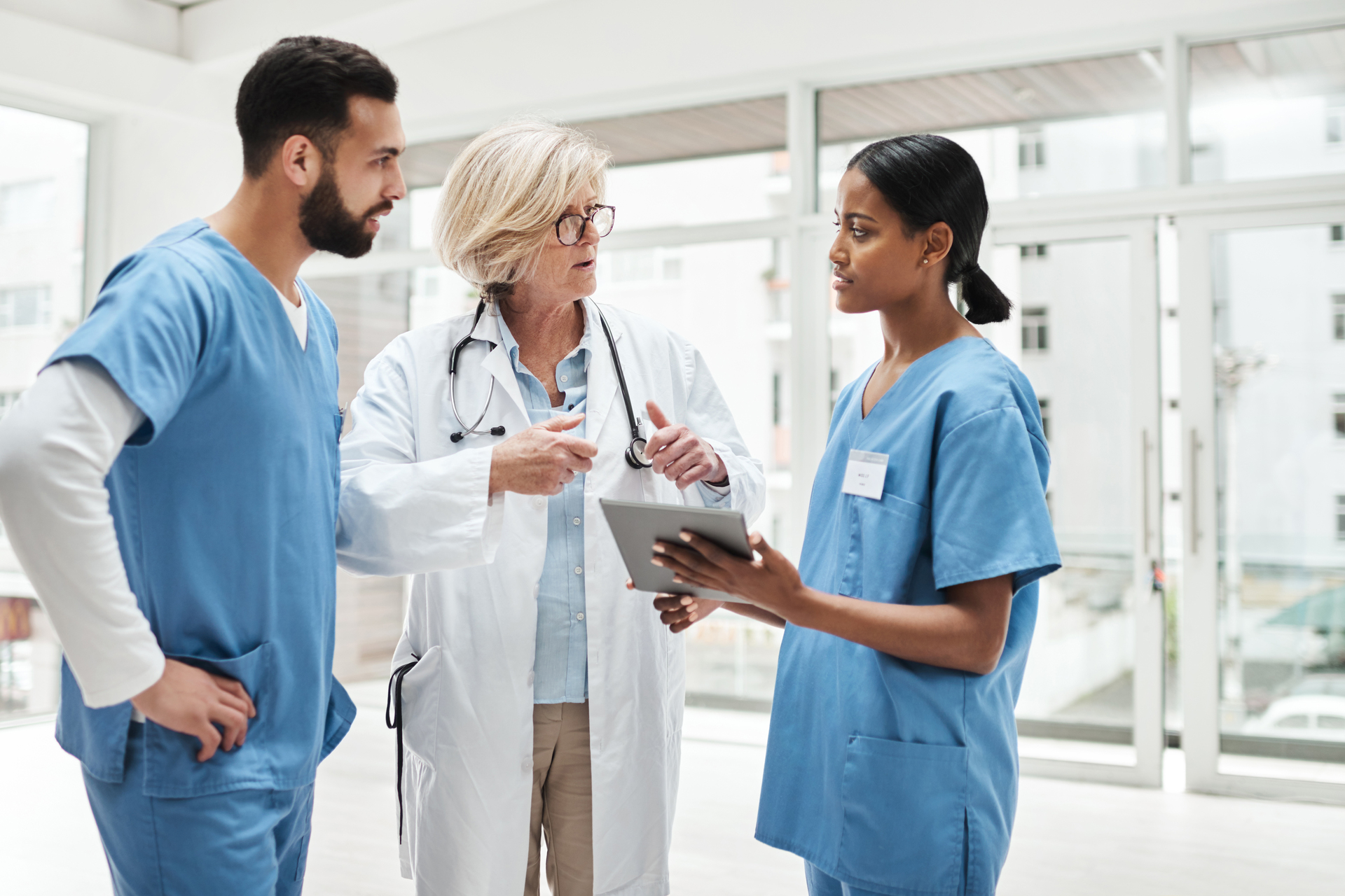 Group of three healthcare workers discussing patient care