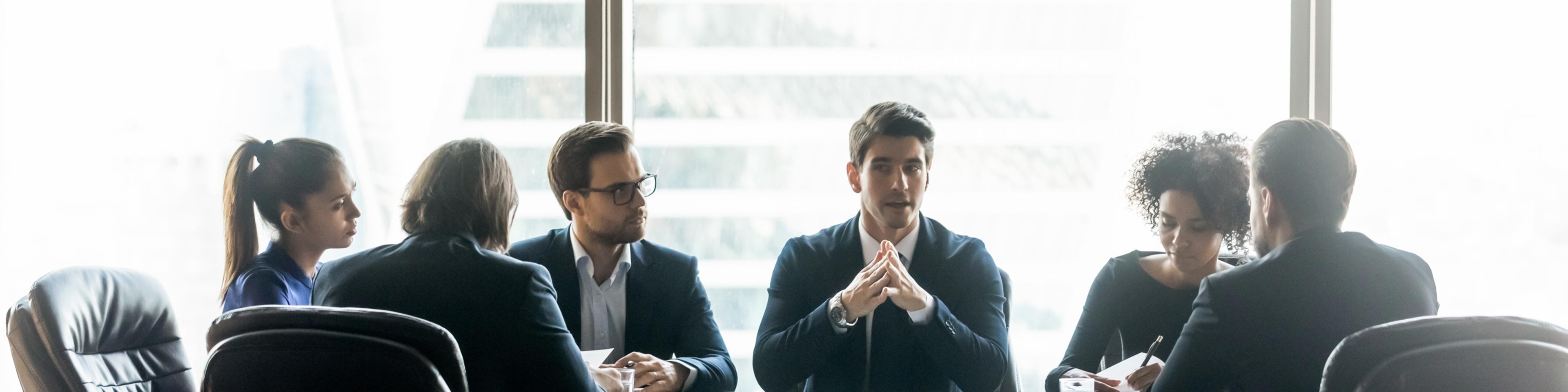 <img src="boardroom.jpg" alt="diverse group of professionals in an executive boardroom engaging in conversation."