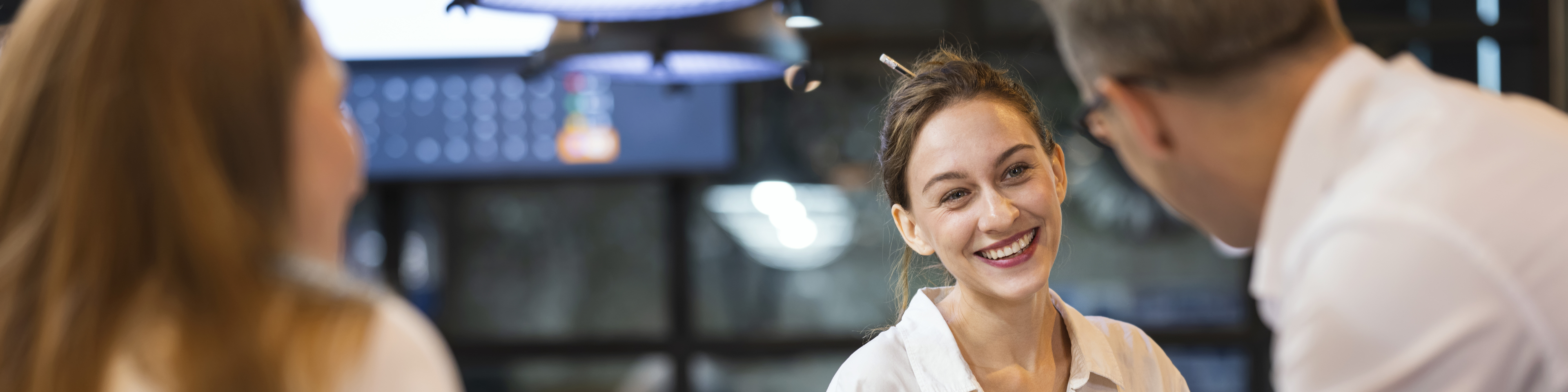 Smiling Female Software Developer leading a project meeting in tech business office