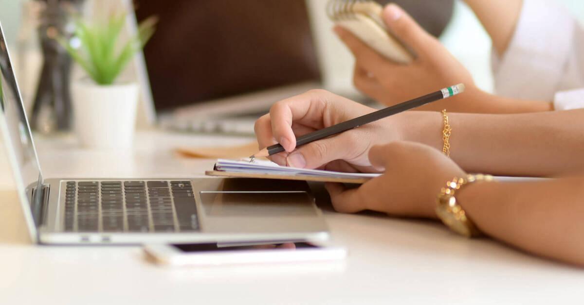 a person sitting at a table using a laptop