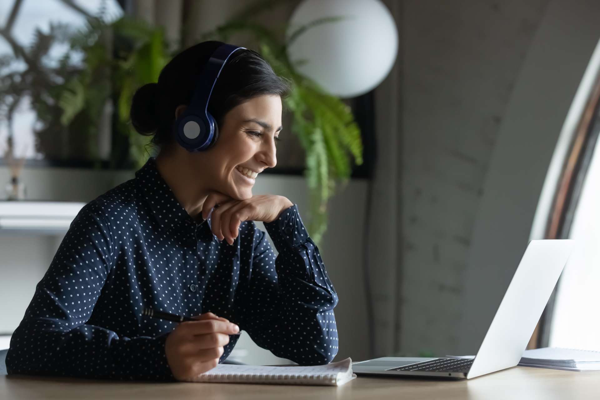 Woman smiling with headset and laptop