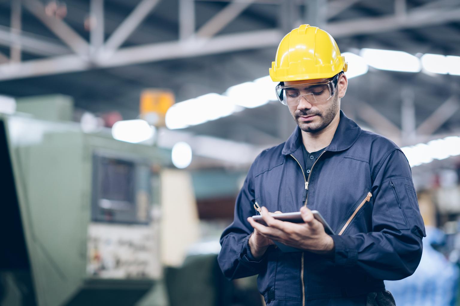 technician engineer standing and checking process on tablet in factory