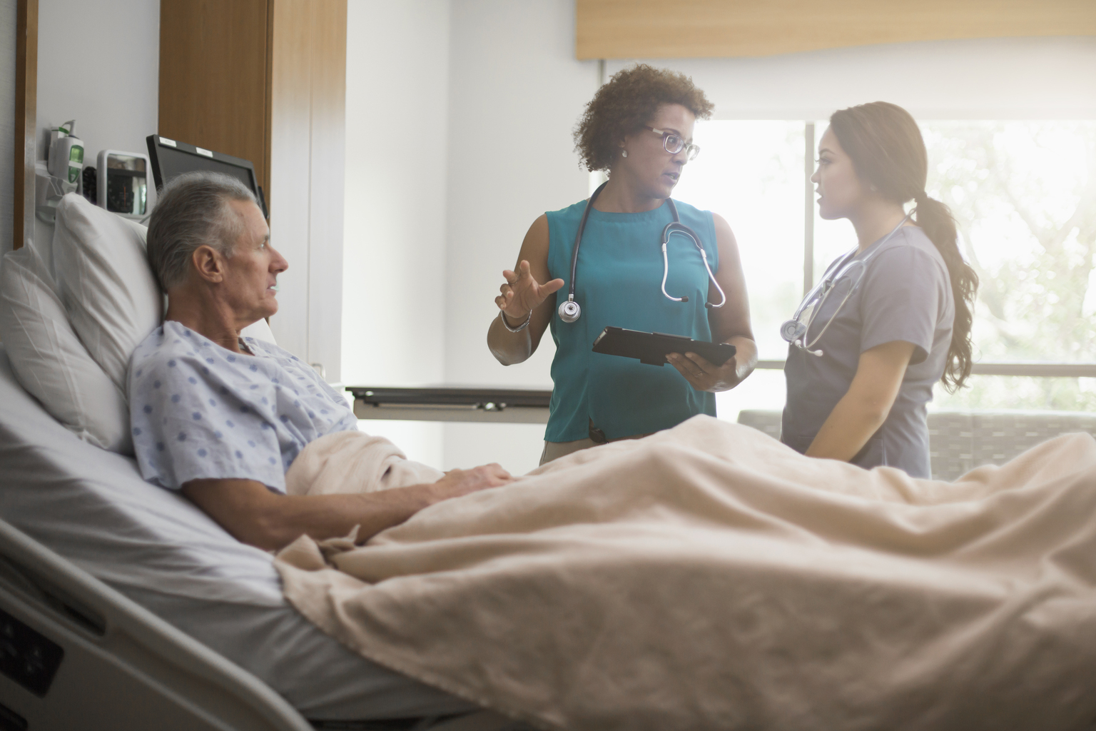 Doctor and nurse with patient in hospital room