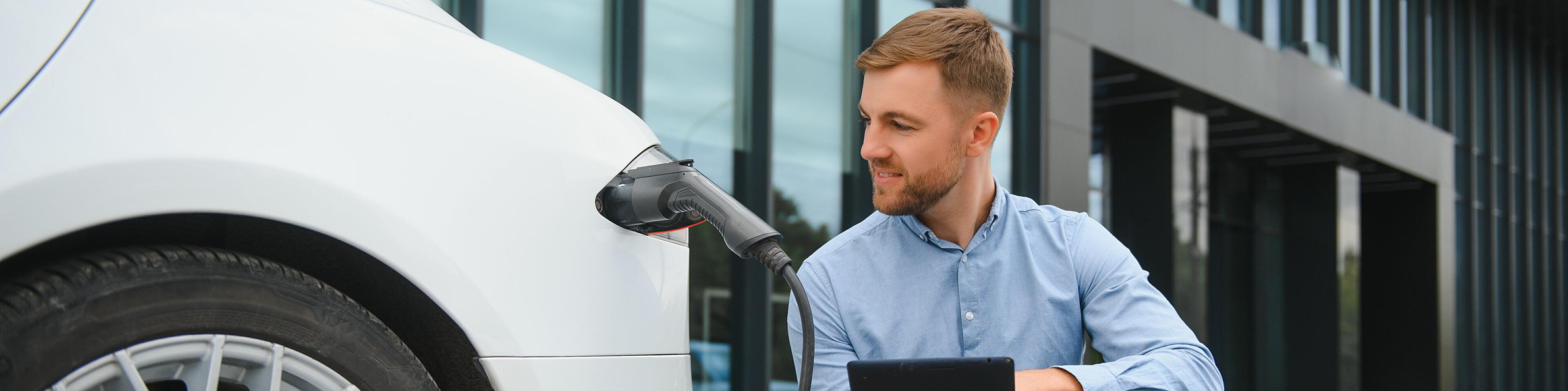 man laadt elektrische auto op