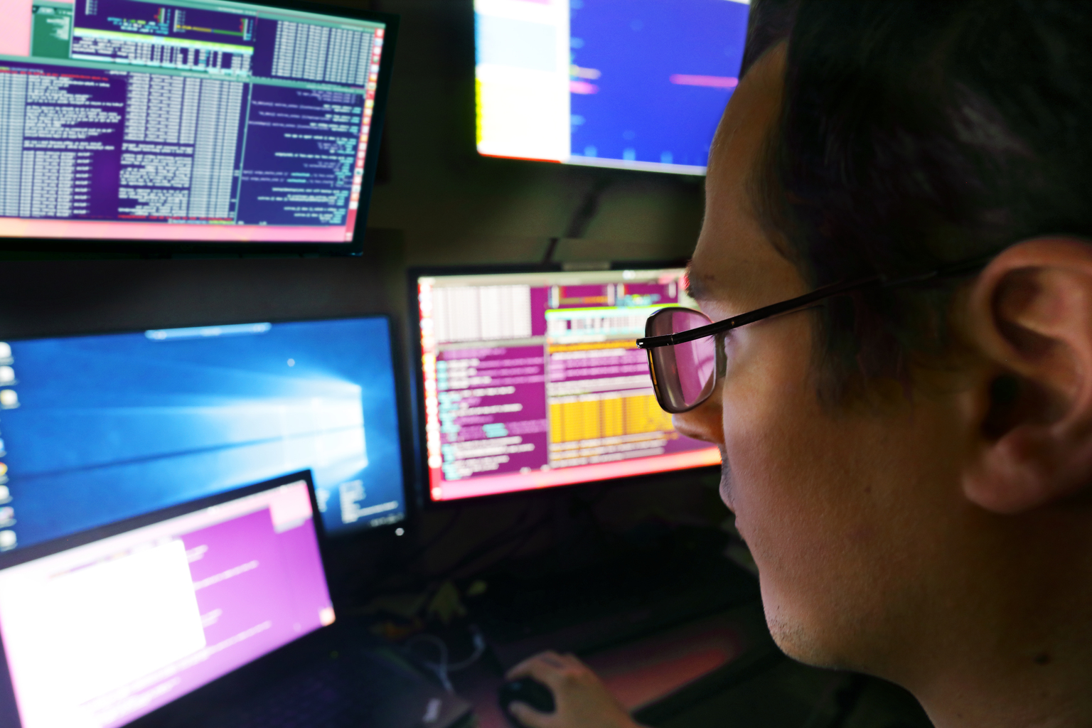 Man wearing glasses looking at computer screens