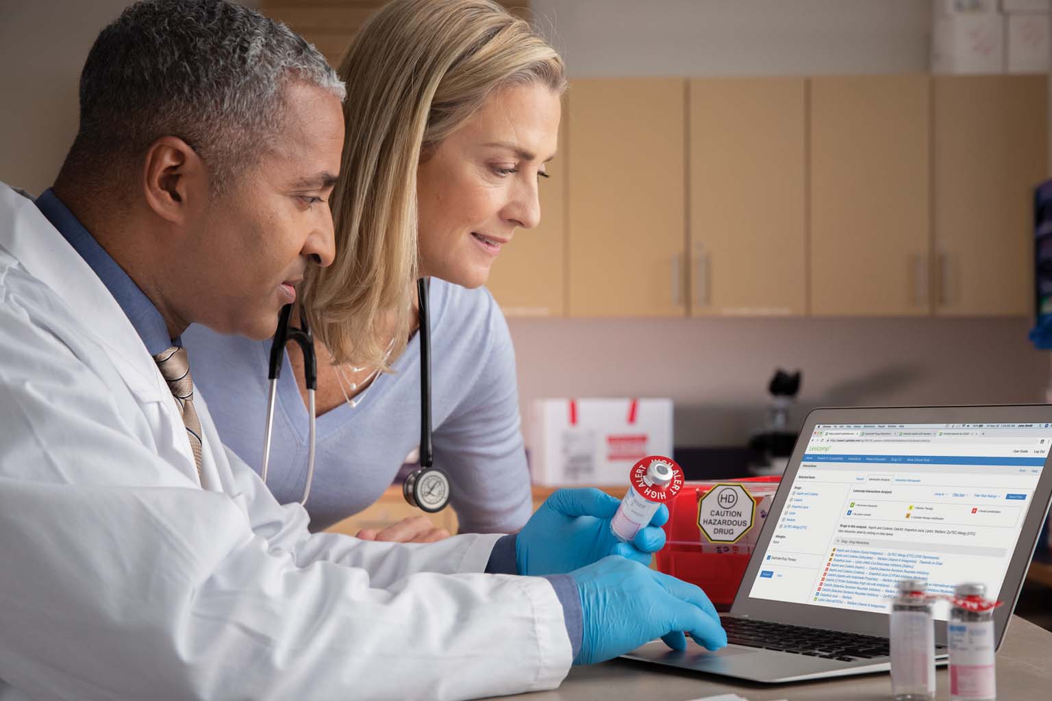 doctor and pharmacist reviewing laptop displaying Lexicomp