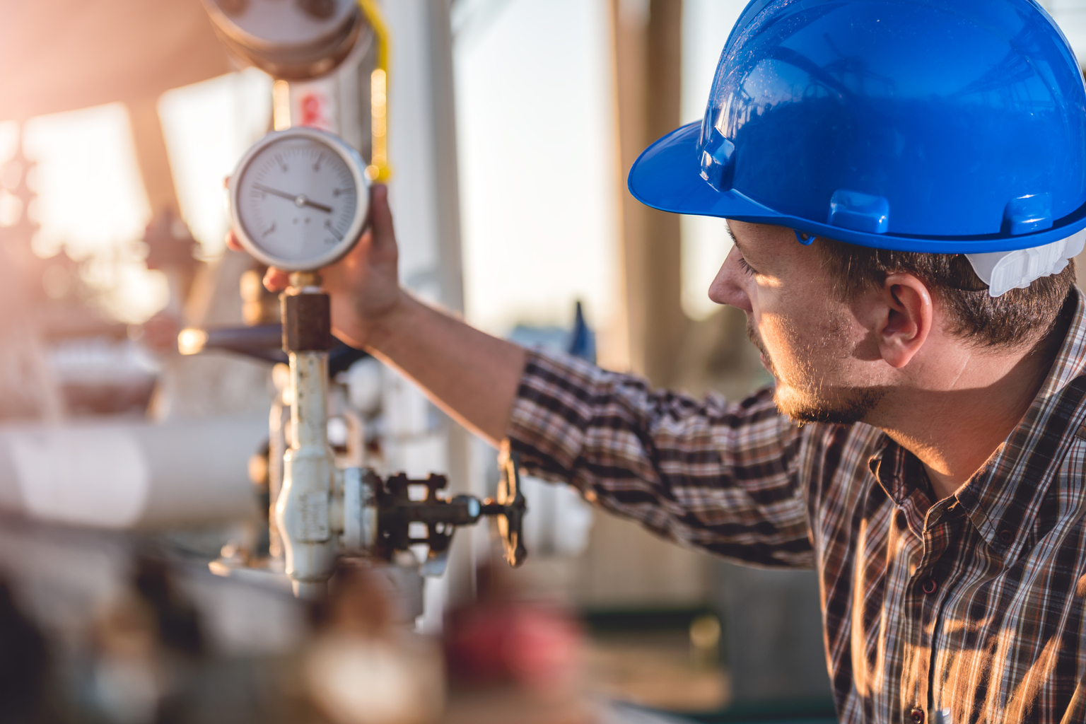 Engineer examining transducer gauge at electric power plant