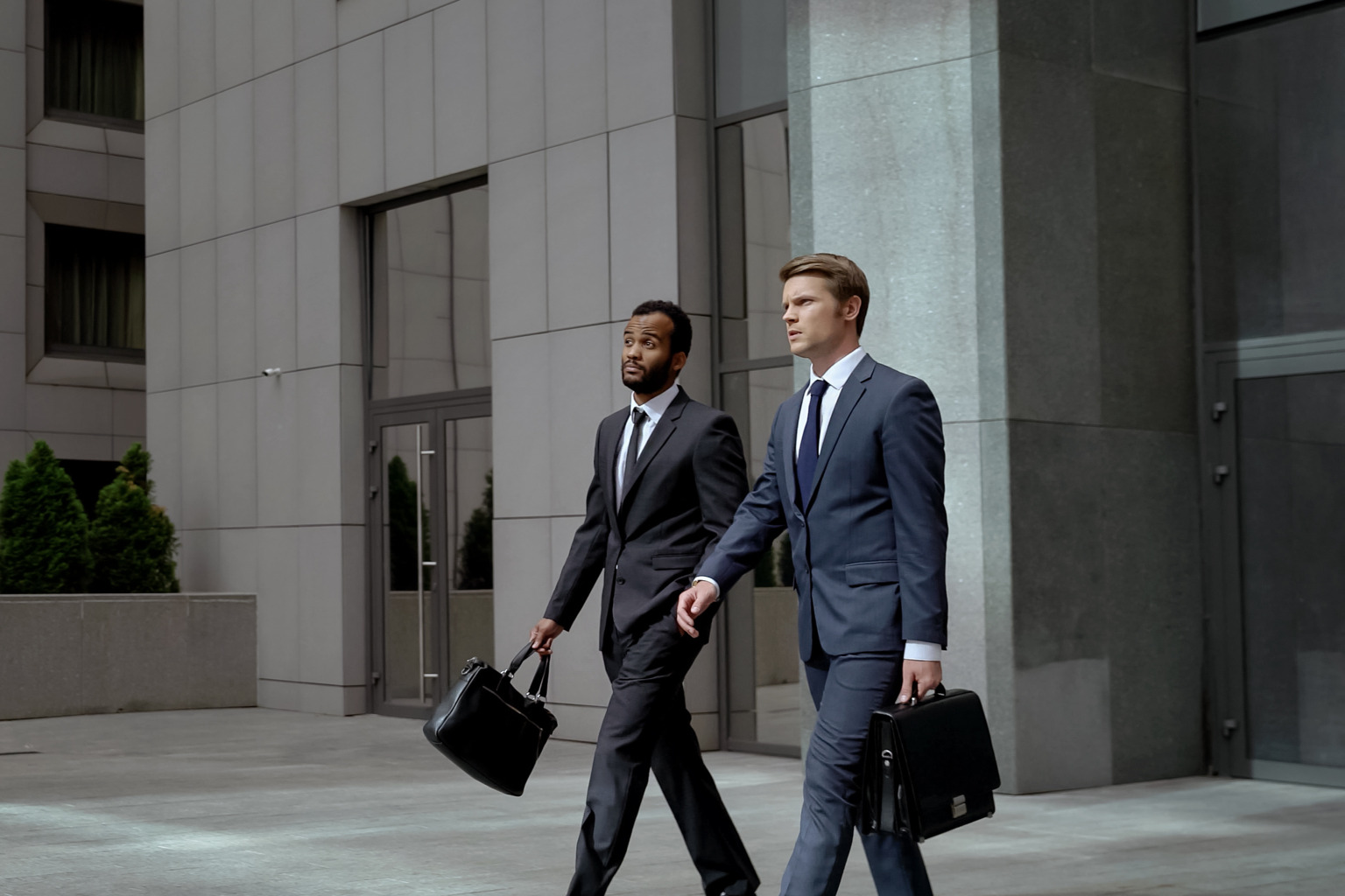 Two businessmen walking out of an office building