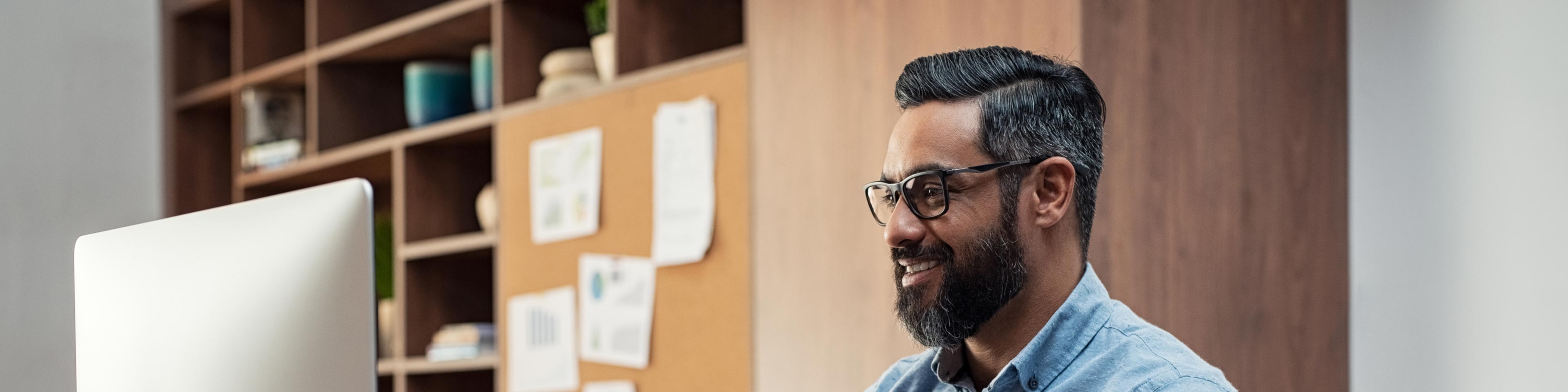 man in office sitting in front of his laptop