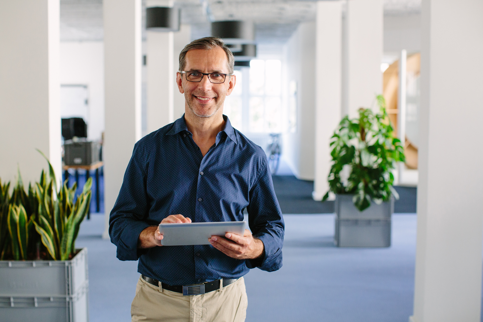 Successful senior businessman standing in office