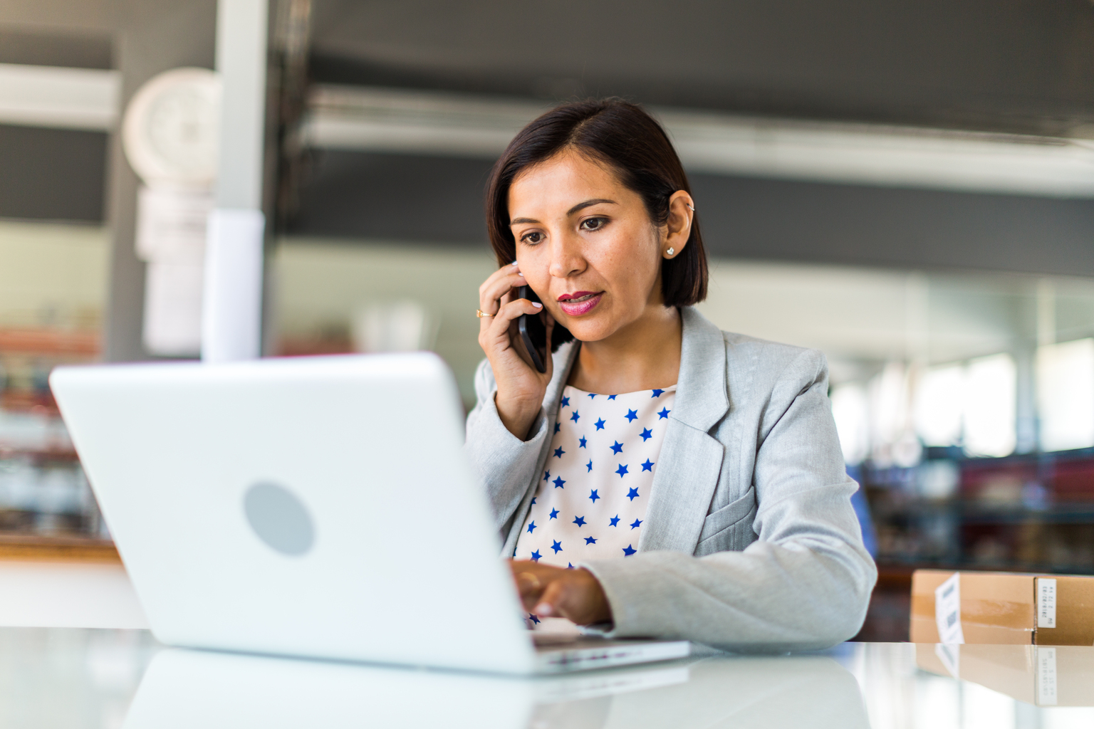 Female business woman in open plan office of a small business 