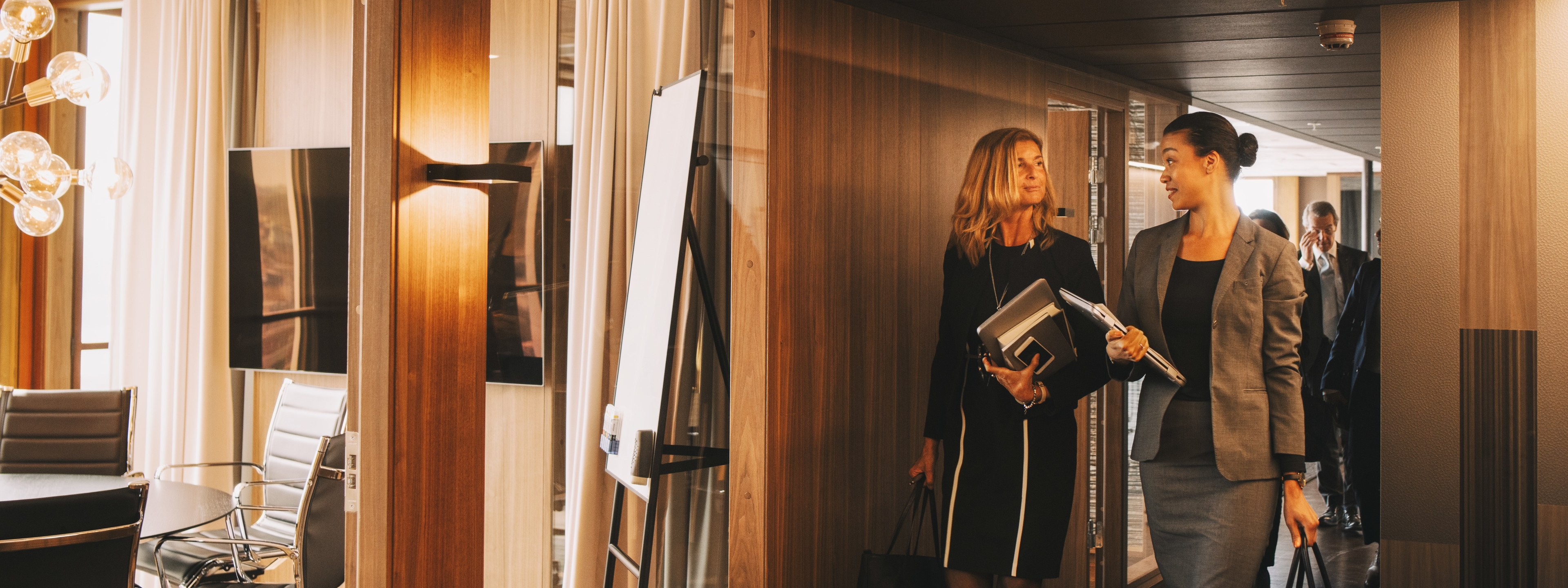 Female lawyers talking while walking in corridor at law office