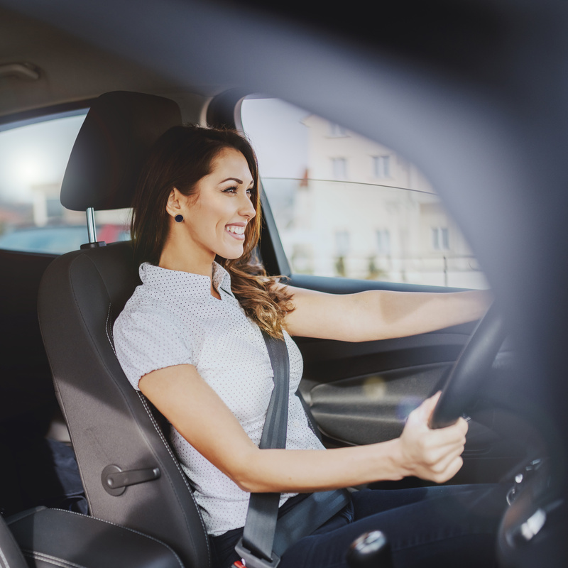 Woman in front seat of Nissan car