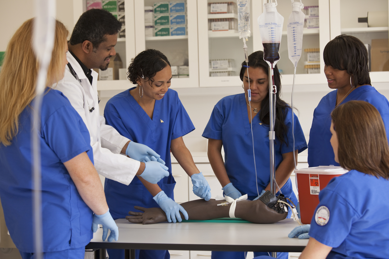 Nurses learning to insert an IV drip in hospital.