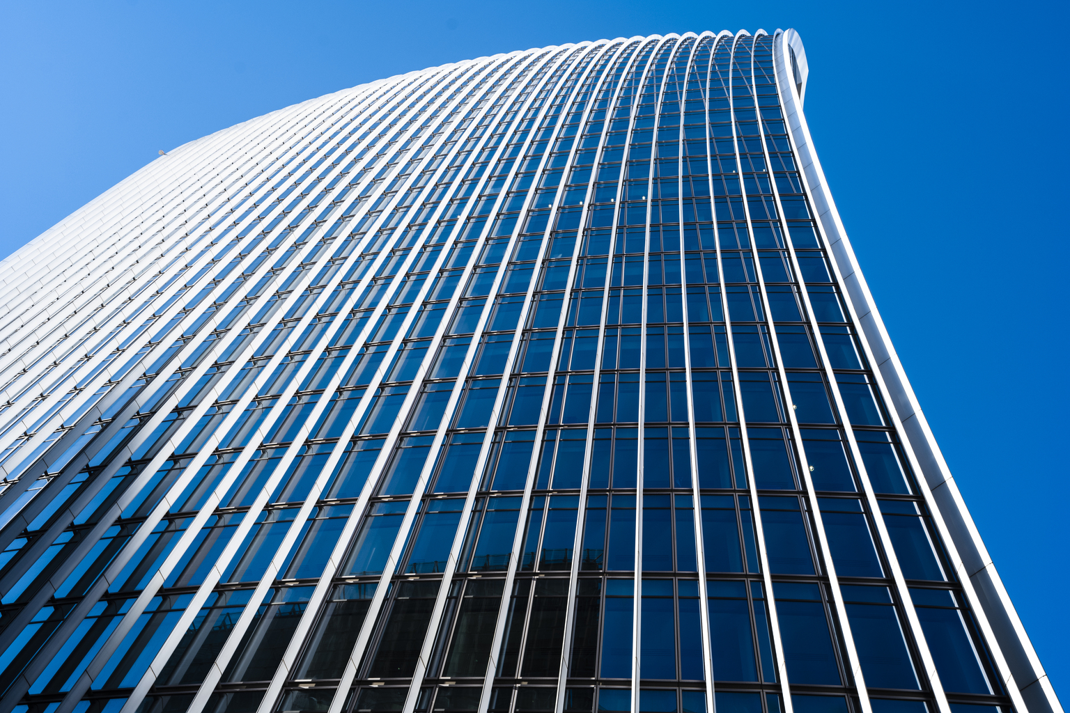 UK, London, looking up at a city skyscraper in the financial district against clear sky