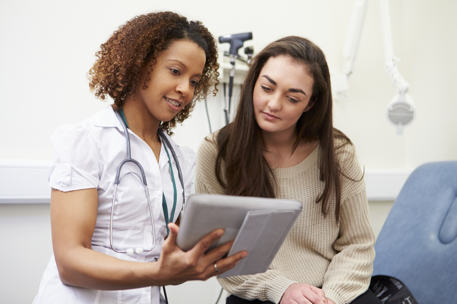 Nurse showing patient test results on digital tablet